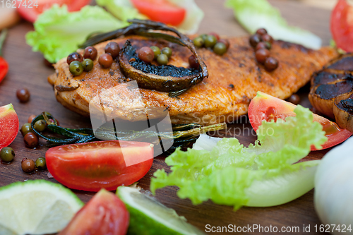 Image of wood fired hoven cooked chicken breast on wood board 