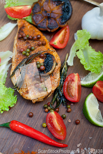 Image of wood fired hoven cooked chicken breast on wood board 