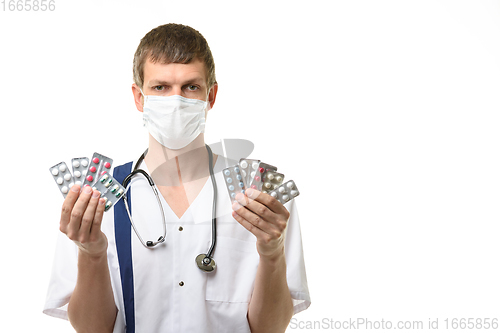 Image of Portrait of doctor with medications in hands, isolated on white background