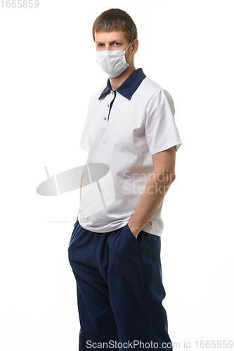 Image of Portrait of a doctor in a medical mask on a white background, the doctor put his hands in his pockets