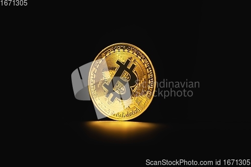 Image of Physical shiny bitcoin agains dark background