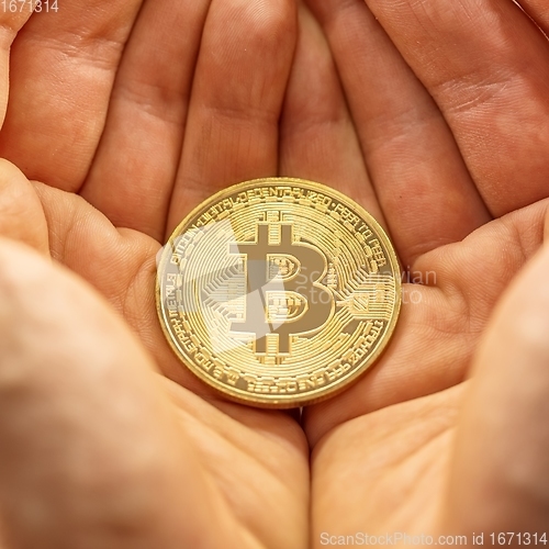 Image of Physical bitcoin held in hands closeup