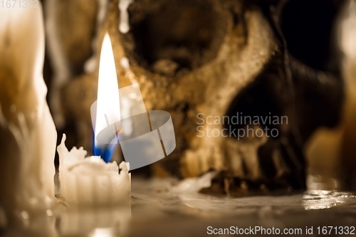 Image of Human skull against dark background in candle light closeup