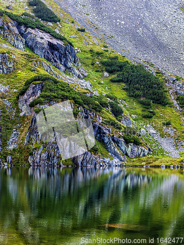 Image of Mountain slope with small lake at botom