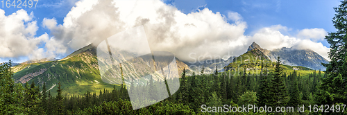 Image of Polish Tatra mountains summer landscape with blue sky and white clouds.