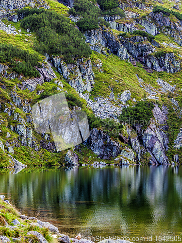 Image of Mountain slope with small lake at botom