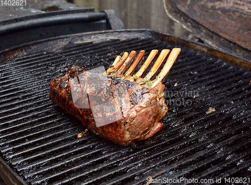 Image of Juicy rack of lamb grilling on a summer barbecue