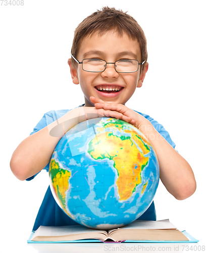 Image of Little boy is holding globe