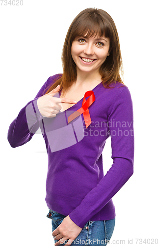 Image of Woman is pointing to the red awareness ribbon