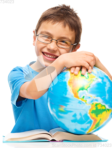 Image of Little boy is holding globe