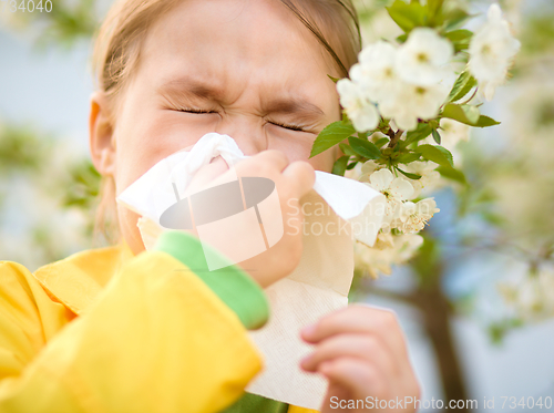 Image of Little girl is blowing her nose