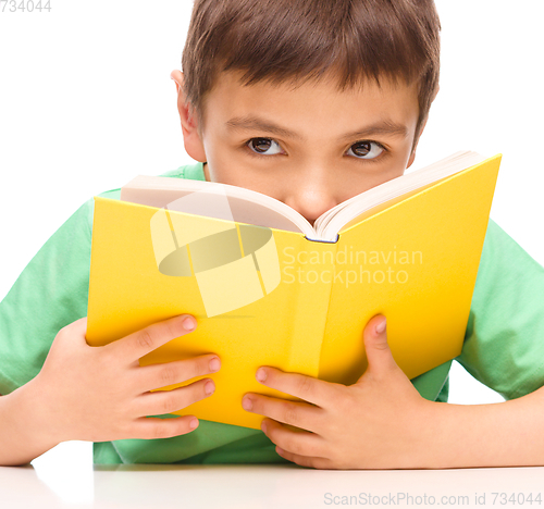 Image of Little boy plays with book