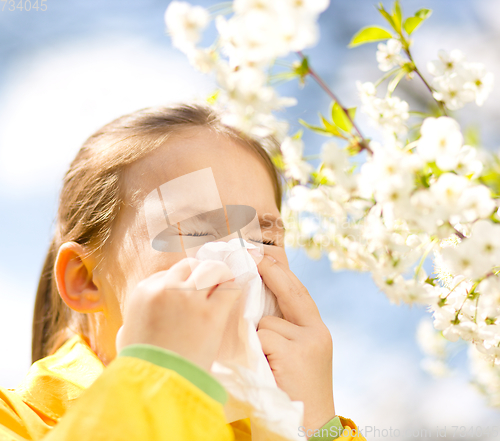 Image of Little girl is blowing her nose