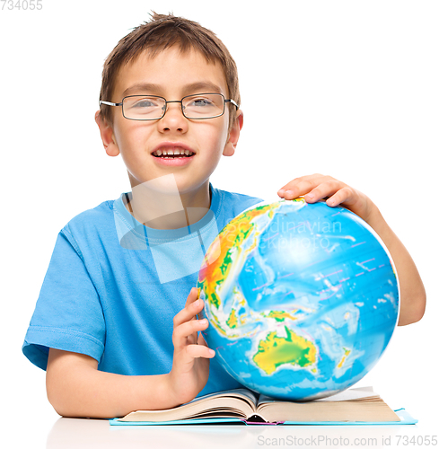 Image of Little boy is holding globe