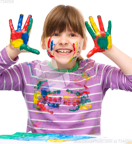 Image of Portrait of a cute girl playing with paints