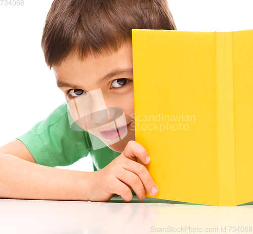 Image of Little boy plays with book