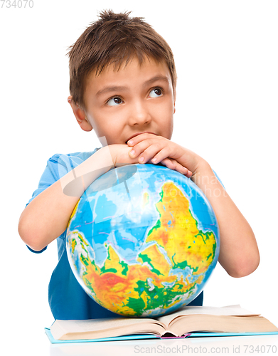 Image of Little boy is holding globe