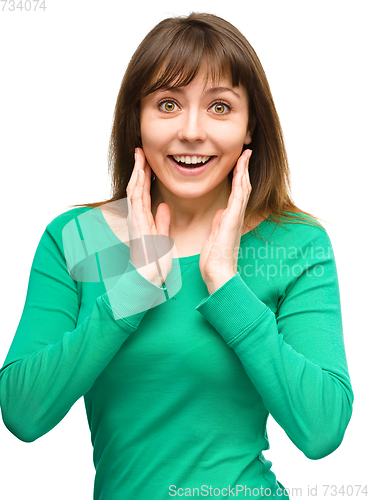 Image of Woman is holding her face in astonishment