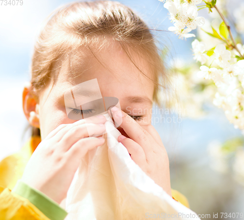 Image of Little girl is blowing her nose