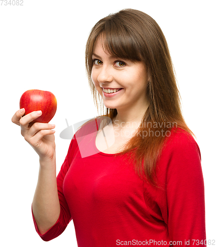 Image of Young happy girl with apple