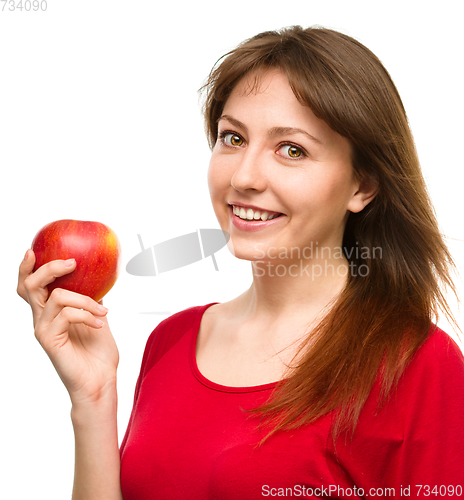 Image of Young happy girl with apple