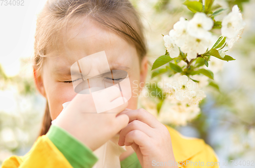 Image of Little girl is blowing her nose