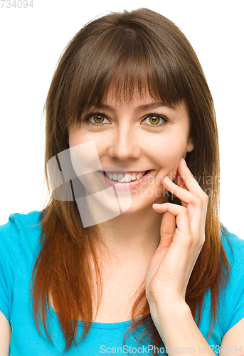 Image of Young woman is touching her cheek with hand