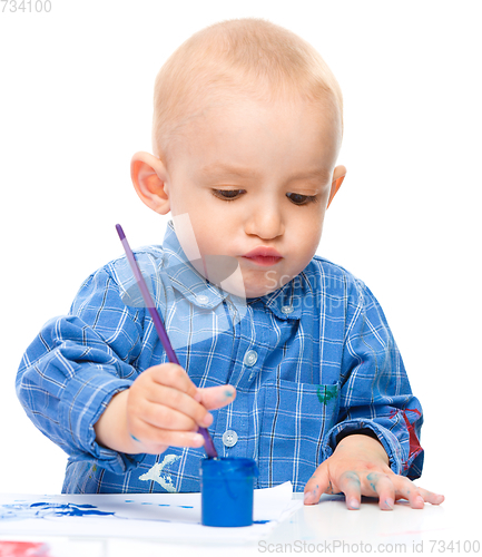 Image of Little boy is playing with paints