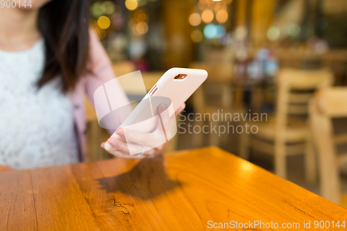 Image of Woman use of cellphone in cafe