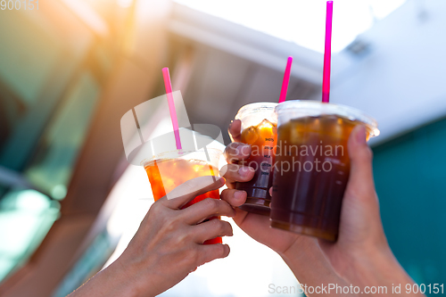 Image of Friends holding iced coffee with sun flare