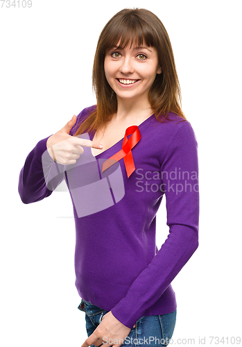 Image of Woman is pointing to the red awareness ribbon