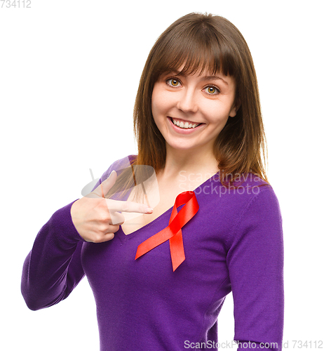 Image of Woman is pointing to the red awareness ribbon