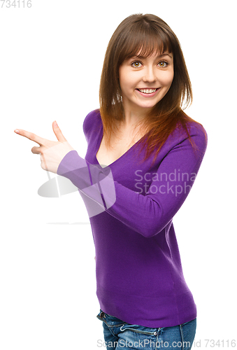Image of Portrait of a young woman pointing to the left