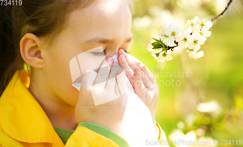 Image of Little girl is blowing her nose