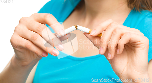 Image of Young woman is breaking a cigarette