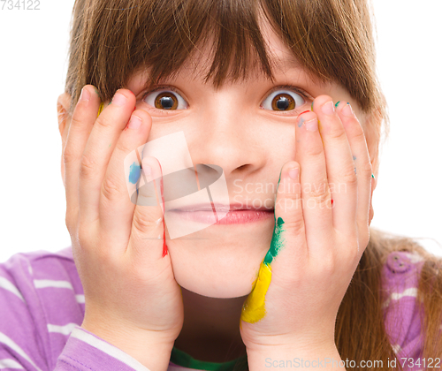 Image of Little girl is holding her face in astonishment