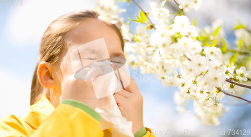 Image of Little girl is blowing her nose