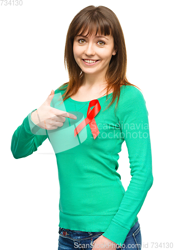 Image of Woman is pointing to the red awareness ribbon