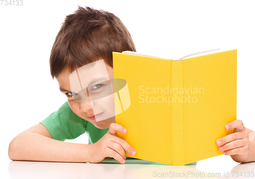 Image of Little boy plays with book