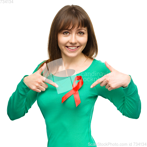 Image of Woman is pointing to the red awareness ribbon