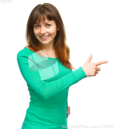 Image of Portrait of a young woman pointing to the right