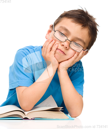 Image of Little boy is tired to read his book