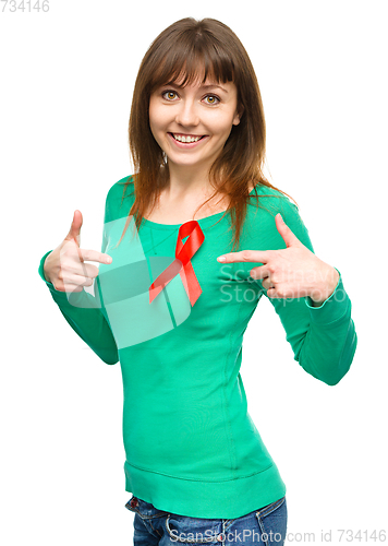 Image of Woman is pointing to the red awareness ribbon