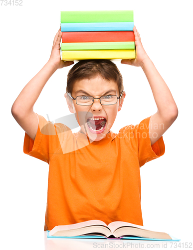 Image of Little boy is holding a pile of books