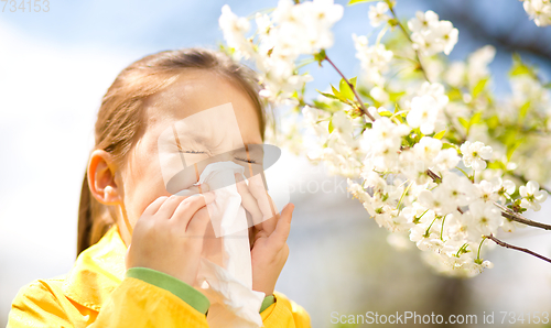 Image of Little girl is blowing her nose