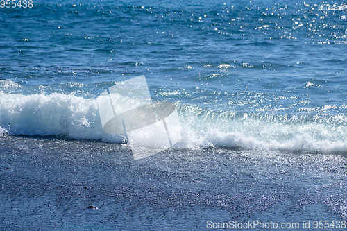 Image of ocean water on black sand