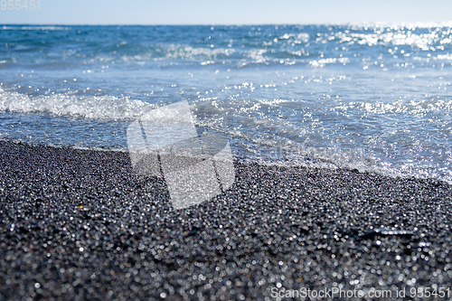 Image of ocean water on black sand