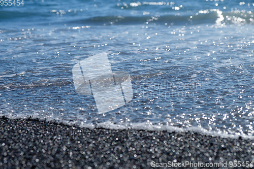 Image of ocean water on black sand