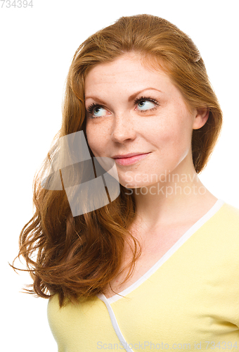 Image of Young happy woman is looking up and smile