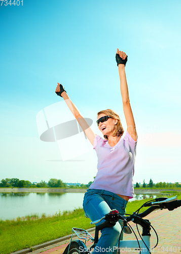 Image of Young woman is sitting on her bicycle